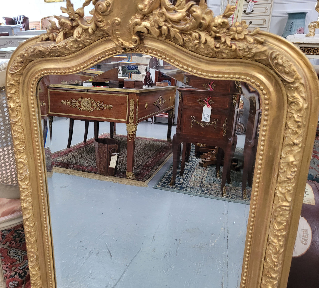 Beautiful French Napoleon III Louis XV style gilt framed bevelled mirror with an ornate crest on top. It has been sourced from France and is in good original detailed condition with the mirror showing signs of age.
