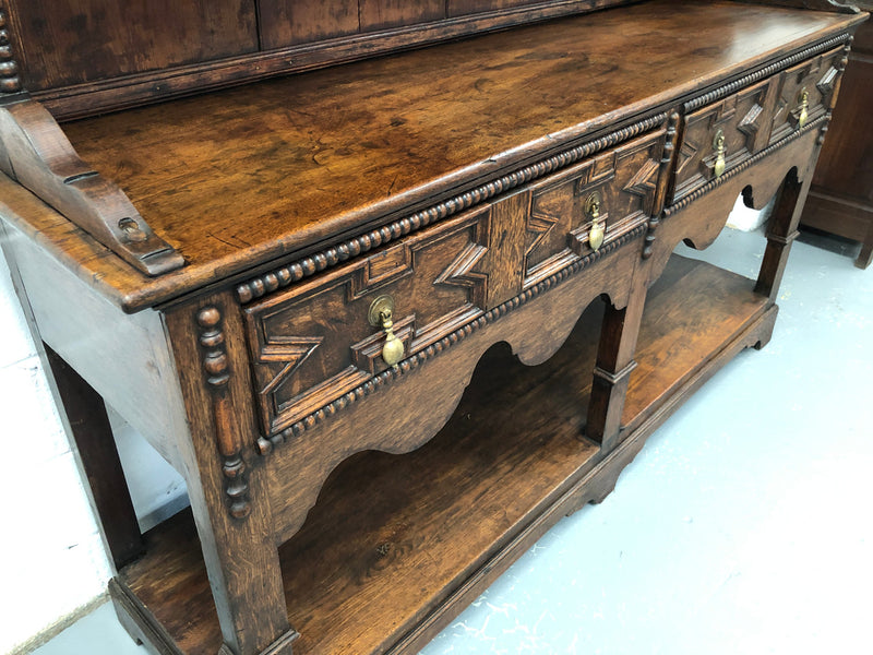 Fabulous Antique Tudor style Oak kitchen dresser with two drawers and two shelves. It is in good original detailed condition.