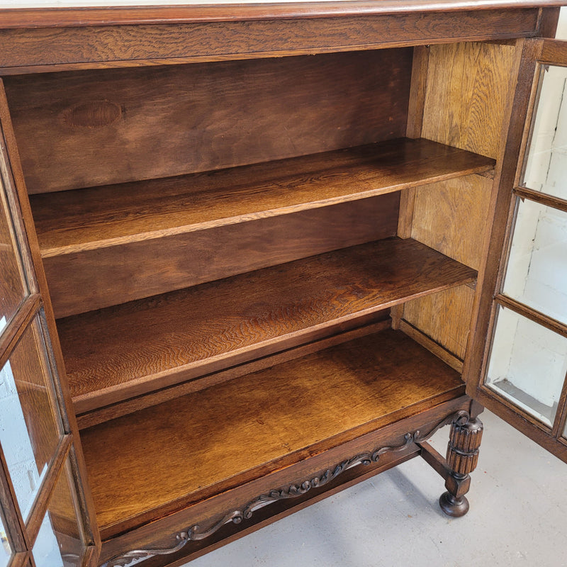 Tudor oak 2 door astral glaze and beveled glass bookcase.  Good original condition. Circa 1930s.
