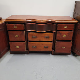 An English Victorian Mahogany sideboard with nine drawers. This amazing piece has loads of storage with three central drawers in the middle and a further six drawers. It has three each side located behind two doors. It has been sourced from locally and in original detailed condition.