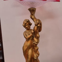 Late Victorian spelter table Centerpiece/comport featuring a woman holding an opalescent and ruby glass bowl. In good original condition with no damage to the ruby bowl.