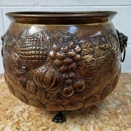 Antique large brass bronze coloured embossed Jardinière/planter with lovely details and lion heads for handles. It is in good original condition.