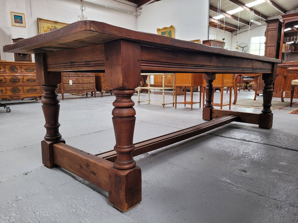 Charming solid rustic Oak stretcher base Farmhouse table. The table is circa 1950's and was custom made using reclaimed oak. It comfortable sits eight and could seat 10. It is in good original detailed condition.