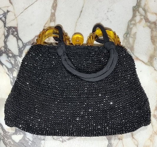 Black fabric vintage style evening bag with amber coloured clasp. In good original condition.