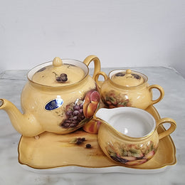 “Aynsley Orchard Gold” tea set on tray. Consisting of small teapot, lidded sugar and creamer. Please view photos as they help form part of the description.