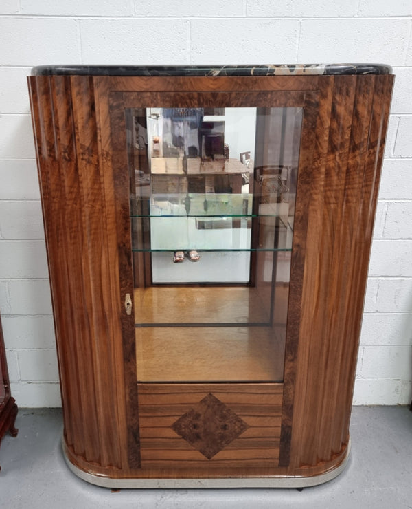 Stunning French Art Deco figured Walnut with Portoro marble top cocktail cabinet. Features chrome trim on base and glass display in door. It is in fully restored condition.