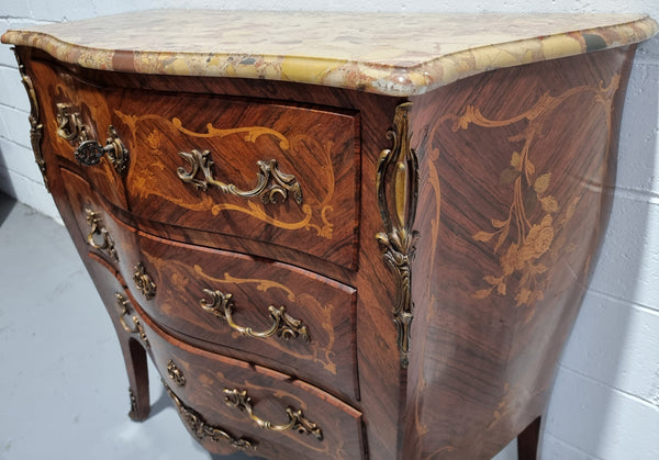 French Marquetry inlaid, three drawer commode with a lovely coloured marble top and beautiful ormolu mounts. This piece is in good original detailed condition.
