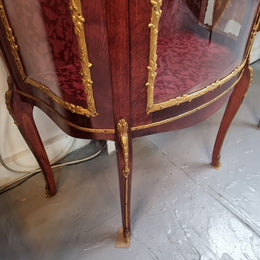 French Mahogany two shelf vitrine with curved glass and brass mounts. It has a lovely frabic interior and two glass shelves. In good original detailed condition.