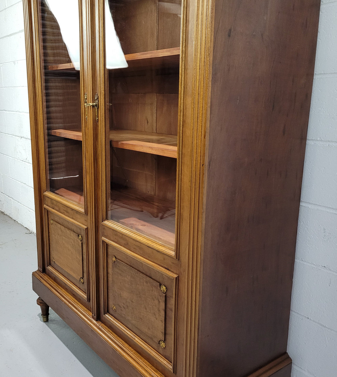 French Walnut two door bookcase with adjustable shelves and lovely ormolu details. It is in good original detailed condition.