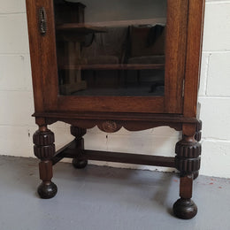 A very practical compact Oak Tudor style display cabinet with three fixed shelves. In good original detailed condition.