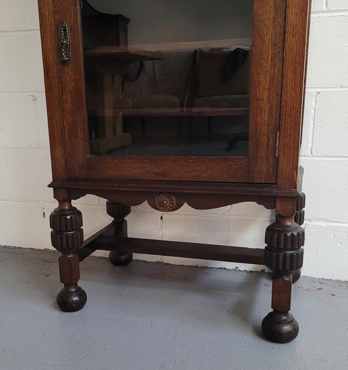 A very practical compact Oak Tudor style display cabinet with three fixed shelves. In good original detailed condition.