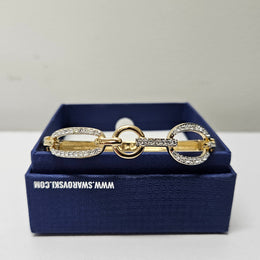 Swarovski gold toned fitted bangle set with Swarovski crystals. Swarovski mark to band, and a side opening. Charming little bracelet. Please see photos as they form part of the description.