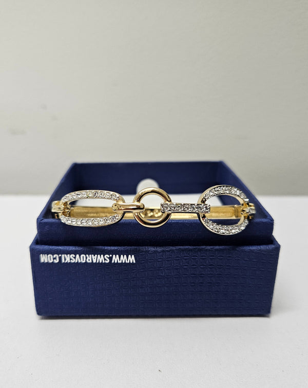 Swarovski gold toned fitted bangle set with Swarovski crystals. Swarovski mark to band, and a side opening. Charming little bracelet. Please see photos as they form part of the description.