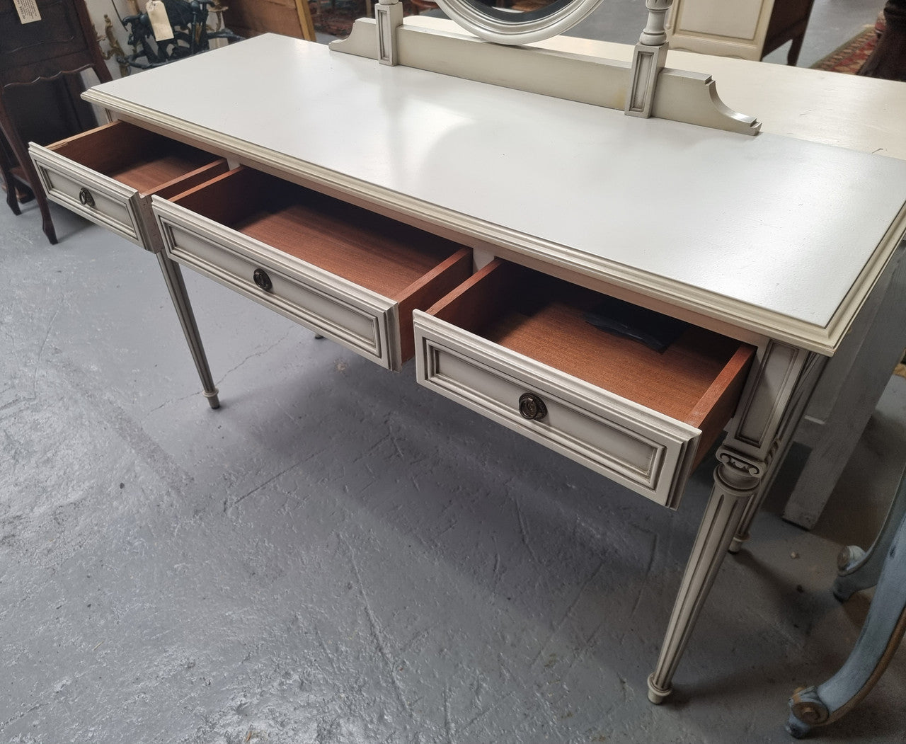 French Louis XVI style painted dresser / console with beveled oval mirror and three drawers. Sourced from France and in good original detailed condition.