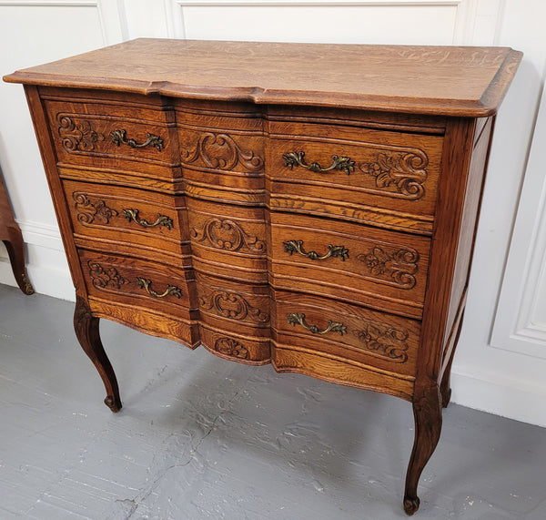 Vintage French dark Oak Louis XV style chest of three drawers. It has beautiful cabriole legs, elegant brass handles and decorative carving throughout. It is in good original detailed condition and has been sourced from France.