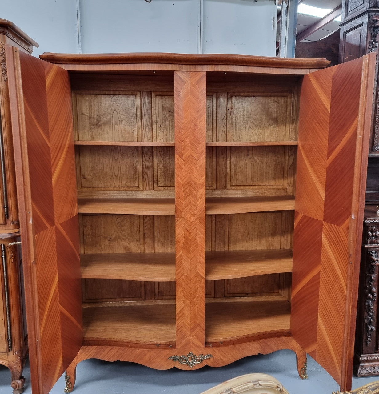 Charming French Louis XV Style Marquetry Inlaid Two Door Armoire. Features three adjustable shelves and ormolu trim. It has been sourced from France and is in good original condition.