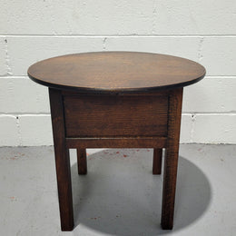 Fabulous round oak side table which also has a hidden sewing box underneath with lovely original blue satin lining and Includes pictured sewing items. It is in good original condition.