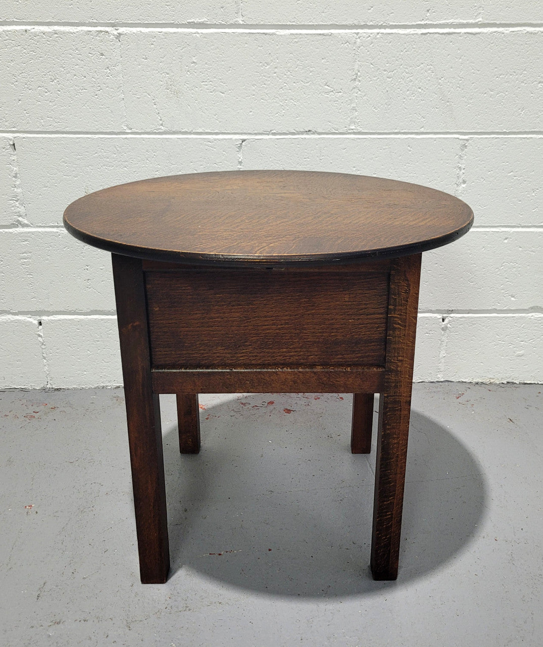 Fabulous round oak side table which also has a hidden sewing box underneath with lovely original blue satin lining and Includes pictured sewing items. It is in good original condition.