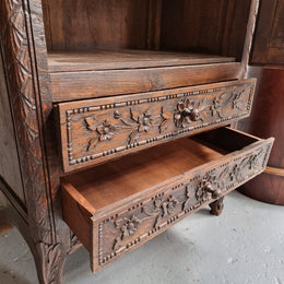 Petite oak armoire display cabinet with a glass door, two drawers at the bottom and three shelves inside. Late 18th Century and amazing detailed decorative carvings. Sourced from France and in good original condition.