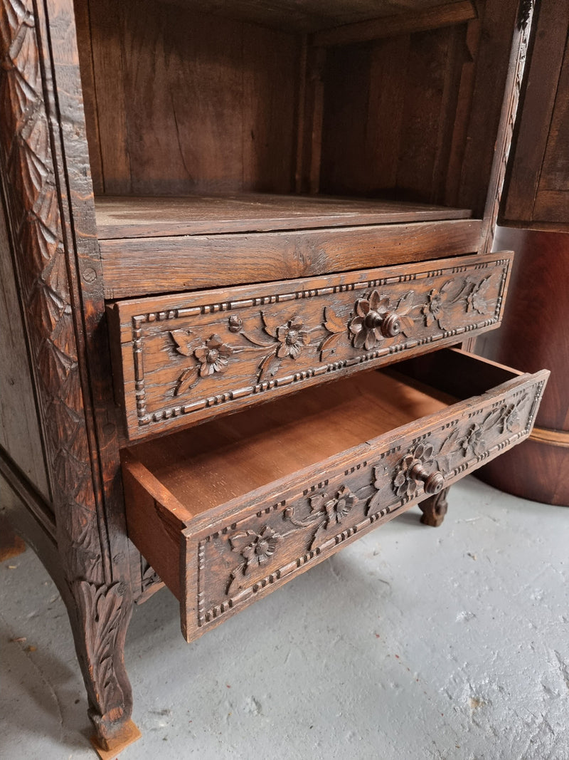 Petite oak armoire display cabinet with a glass door, two drawers at the bottom and three shelves inside. Late 18th Century and amazing detailed decorative carvings. Sourced from France and in good original condition.