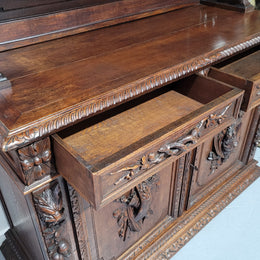 Grand French Oak Gothic style buffet with amazing detailed carvings. This stunning buffet has a display section at the top with two adjustable shelves, two drawers in the middle with elegantly carved handles and storage below with one fixed shelf. It is in good original detailed condition.