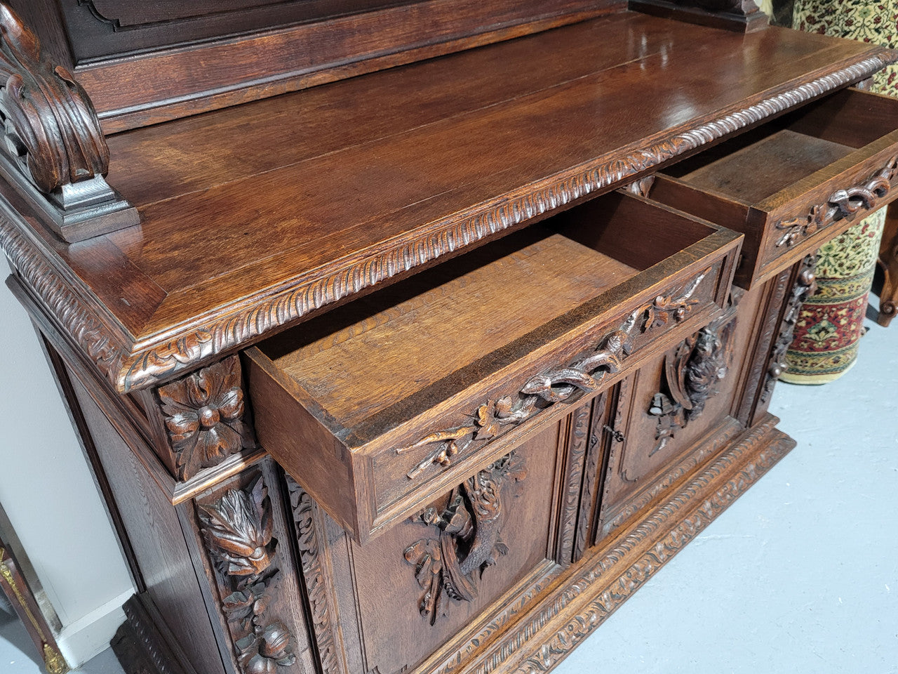 Grand French Oak Gothic style buffet with amazing detailed carvings. This stunning buffet has a display section at the top with two adjustable shelves, two drawers in the middle with elegantly carved handles and storage below with one fixed shelf. It is in good original detailed condition.