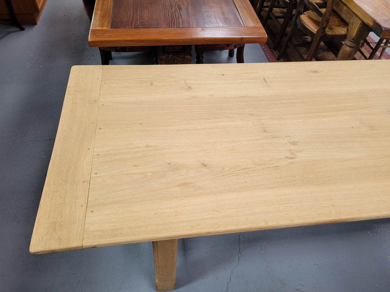 French raw Oak stretcher based refectory table. Features raw wood that could be used as is for a distressed look, or finished and waxed for a more refined look. Sourced from France and in good original condition.