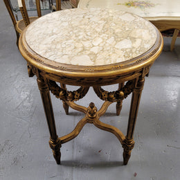 French Louis XVI style round marble topped gilded lamp/side table featuring lovely carved swags and undercarriage. It has been sourced from France and is in good original detailed condition.