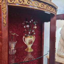 French Mahogany two shelf vitrine with curved glass and brass mounts. It has a lovely frabic interior and two glass shelves. In good original detailed condition.