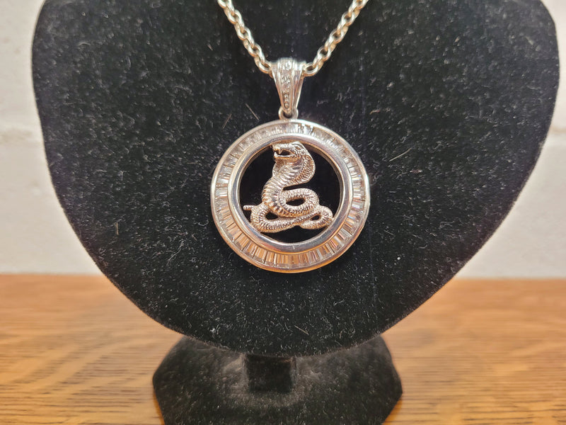 Sterling Silver pendant featuring a Cobra Snake with Cubic Zirconia surround. Heavy Bale with Cubic Zirconia. Pendant without Bale, 3.5cm Diameter. Includes 60 cm Sterling Silver Chain.