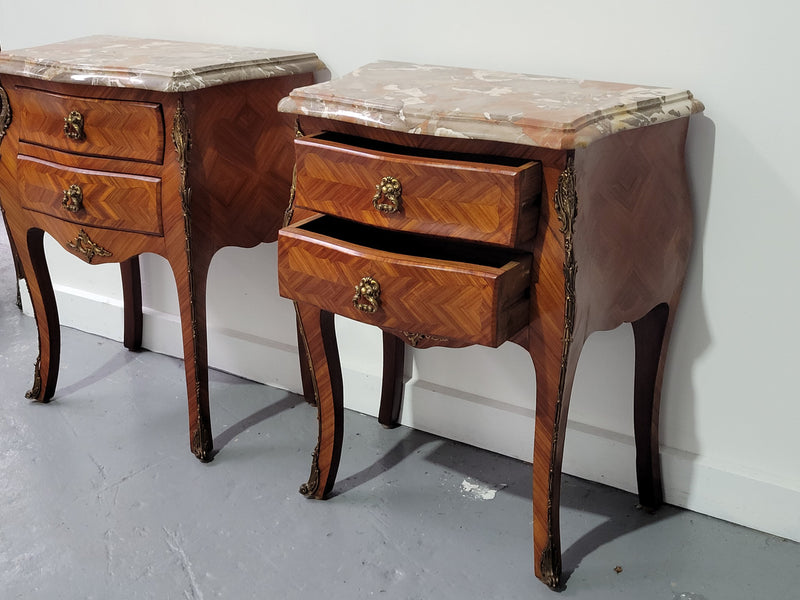 Pair of Louis XV commode style two drawer bedsides with beautiful marble tops and decorative mounts. They are a rare size and are in good, detailed condition.