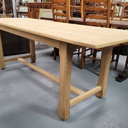 French raw Oak stretcher based refectory table. Features raw wood that could be used as is for a distressed look, or finished and waxed for a more refined look. Sourced from France and in good original condition.