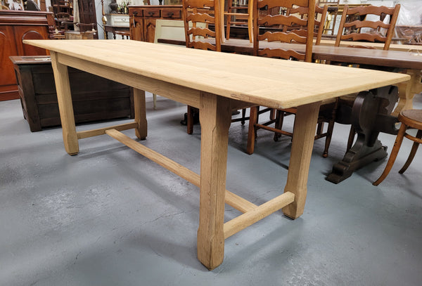 French raw Oak stretcher based refectory table. Features raw wood that could be used as is for a distressed look, or finished and waxed for a more refined look. Sourced from France and in good original condition.