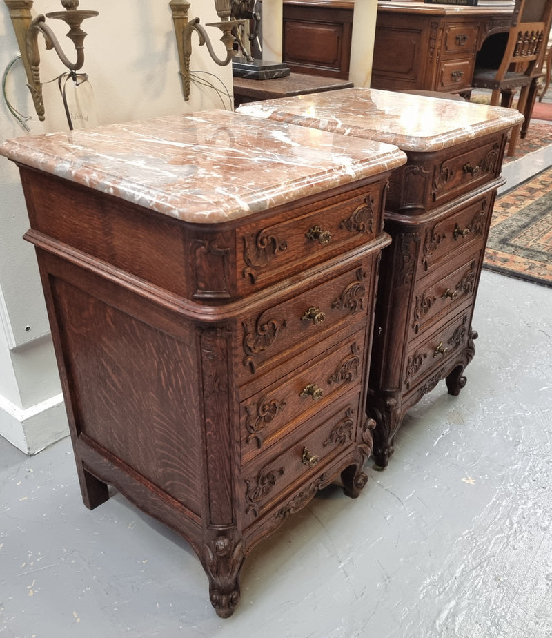 A pair of hard to find French Oak Louis XV style four drawer marble topped bedsides with attractive carvings. They are in good original detailed condition and have been sourced from France.
