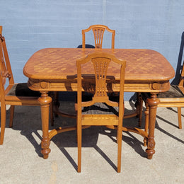 Beautiful carved French Oak dining table with a parquetry top and six matching upholstered chairs. All in good original detailed condition.