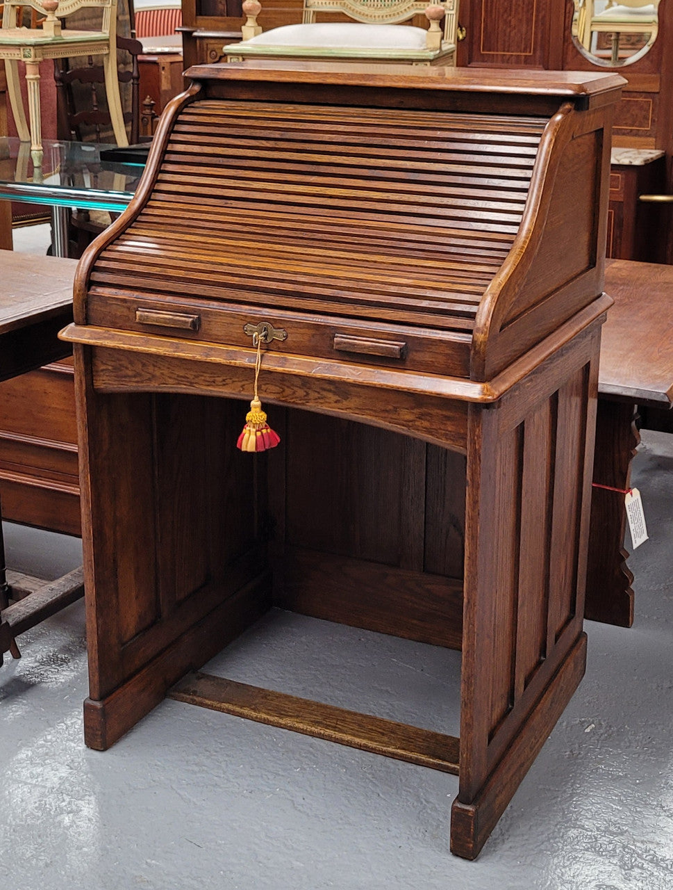 Charming petite English Oak fitted roll top desk. It has a very lovely fitted interior and a drawer at the front ideal for a unit or apartment. Sourced locally and in good original detailed condition.