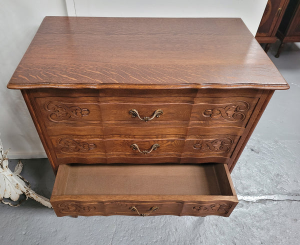 French Oak Louis XV style three drawer commode. It has been sourced from France and has decorative handles and carvings. It is in good original detailed condition.