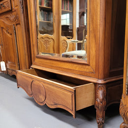 French Louis XV style Walnut armoire with single bevelled mirrored door. It has four adjustable shelves and a hidden exterior drawer at the bottom. It has been sourced from France and is in good original detailed condition.