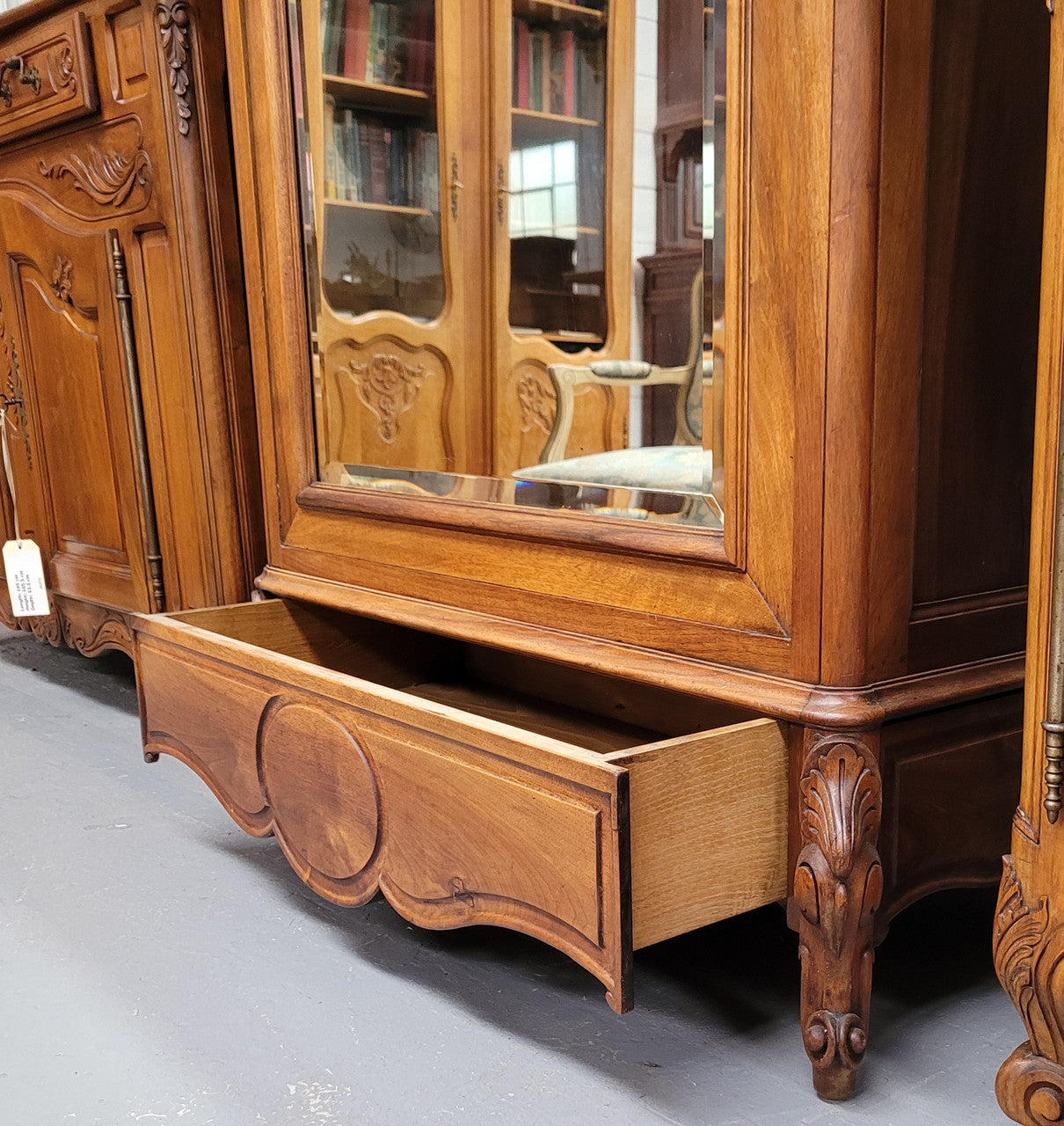 French Louis XV style Walnut armoire with single bevelled mirrored door. It has four adjustable shelves and a hidden exterior drawer at the bottom. It has been sourced from France and is in good original detailed condition.