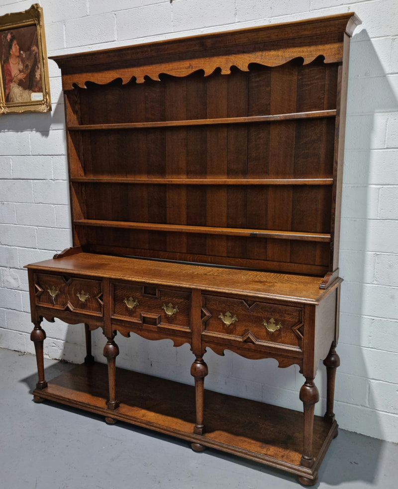 Lovely Antique Oak Tudor style kitchen dresser base with three deep drawers and lovely hardware. In good original detailed condition. There is also a dresser top with three shelves for display purposes. This piece can be purchased with or without top Price is the same either way.
