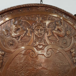 A beautiful European antique repousse copper shield, depicting a battle scene and with metal swords. It has been sourced from France and is in good original condition.