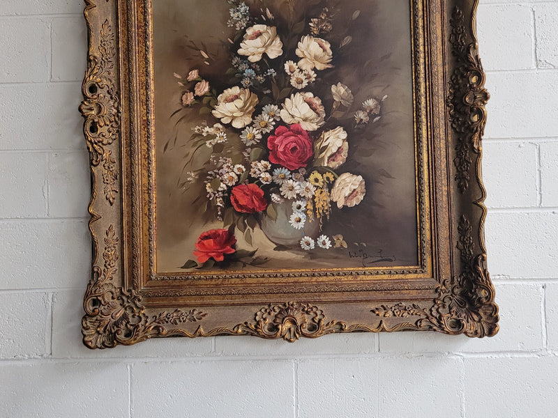 Attractive French floral oil on canvas - signed. Mounted in a stunning patterned gilded frame. It is in good original detailed condition.