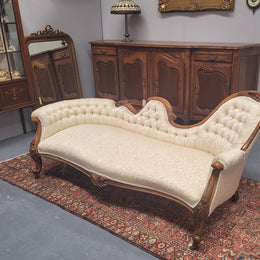 Upholstered Victorian walnut double ended chaise lounge with nice decorative carving. It has original castors and in very good condition. The upholstery is in "like new condition".