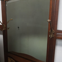 Beautiful English Edwardian tiled back hall stand, with nine brass hooks, two small drawers and retaining it's original mirror and showing signs of age. In good original condition.