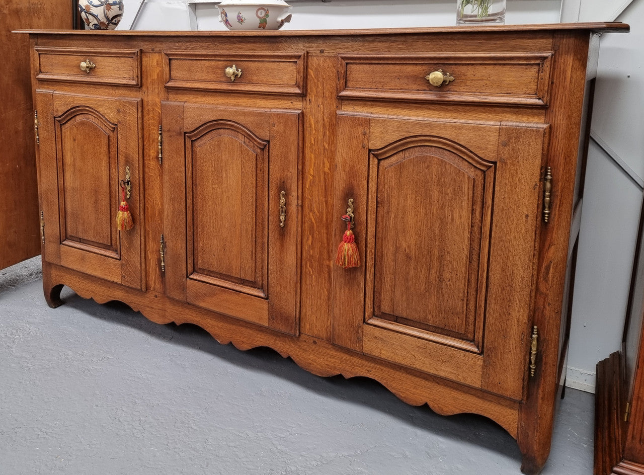 French Oak early 19th century three door buffet. It has a classic simple look and has three cupboards and three drawers. It is in good original detailed condition.