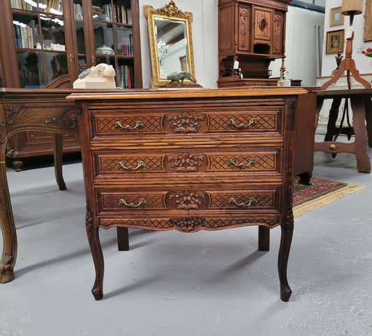 Rustic Louis XV style Oak petite three drawer chest featuring attractive carvings. It has been sourced locally and it is in good original detailed condition.