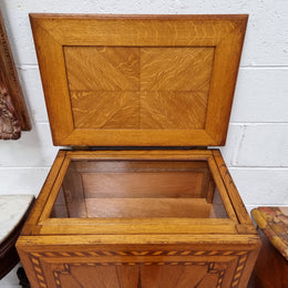 French Art Deco inlaid Oak curio/side cabinet with a lift up top and glass underneath. There are two fixed shelves, two adjustable shelves and one hidden drawer. Sourced from France and in good original condition.