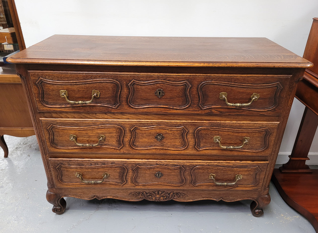 French Provincial Oak three drawer wooden top commode. It has elegant carvings and handles. It has been sourced from France and is in good original detailed condition.