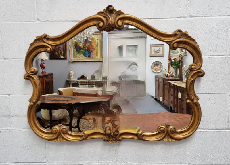 French Louis XV style wood carved and gilded mirror. Mirror is original and showing signs of age. It has been sourced from France and  in good original condition.