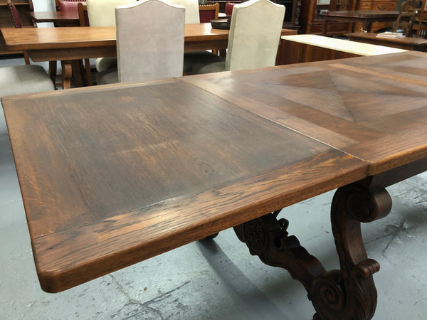 French Oak Renaissance style extension table with a lovely parquetry top and decorative carved and iron base in good original detailed condition.